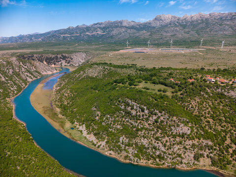 Aerial view of the Suncana elektrana Obrovac solar power plant and wind turbines near the Zrmanja river canyon and Velebit mountains in Zaton Obrovacki, Zadar County, Croatia.