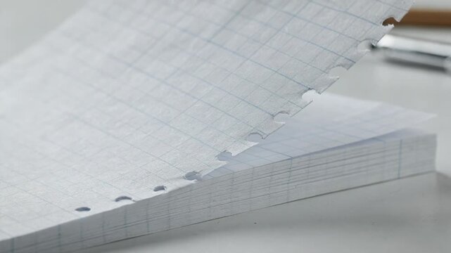 Graph paper notepad pages neatly detaching along perforations emphasizing precision and organization for technical drawings and detailed office work.