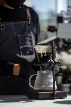 Close up of manual pour over coffee dripping into glass server