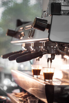 Professional espresso machine brewing double shot coffee into glasses