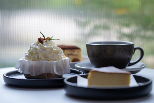 Assorted gourmet desserts and hot coffee cup on table