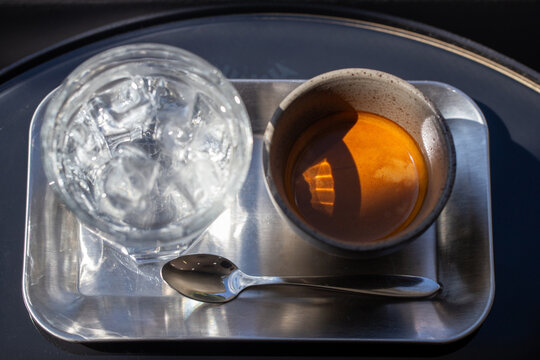 Fresh espresso shot served with a glass of iced water