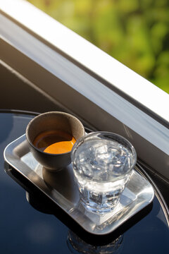 Premium espresso coffee shot and iced water on cafe table