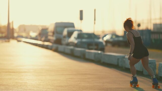 Tattooed woman roller skating during sunset