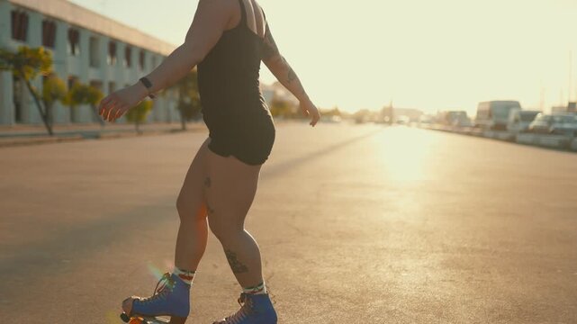 Young tattooed woman roller skating on a street during a beautiful sunset