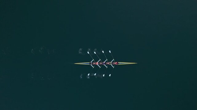 Four determined women rowers power through the calm waters of Halifax Bay as the sun rises, embracing nature and showcasing their fitness with every stroke