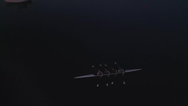 Four determined women rowers glide across the tranquil Halifax Bay at dawn, embracing fitness and nature's beauty under the soft morning light
