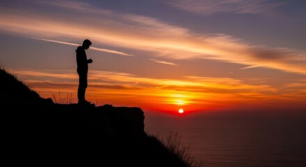 Fototapeta premium Silhouette of a person contemplating sunset over horizon with vibrant colors