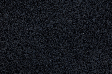 Fototapeta premium The background image shows a freshly laid asphalt surface, just a few hours old, with a clear, almost completely black texture.