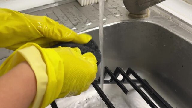 Kitchen cleaning, gloved hands washing stove grate under running water in sink, spring cleaning, home hygiene, deep cleaning and everyday household chores