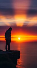 Fototapeta premium Silhouette of a person watching sunset over water horizon