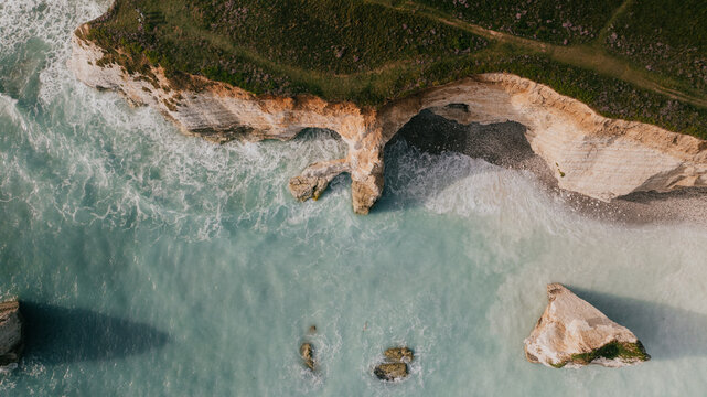 Aerial top down view of chalk cliffs and natural sea arch