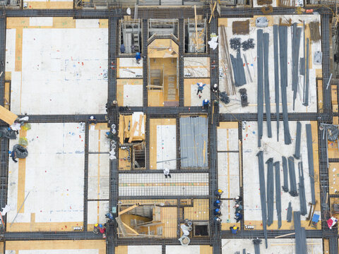 Aerial view of a construction site with workers, steel rebar, and wooden formwork for a new building foundation Taiwan.