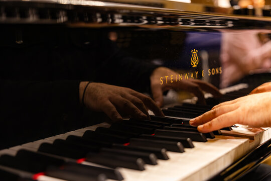Close up of pianist hands playing Steinway and Sons grand piano