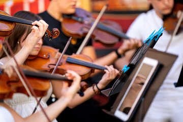 Young musicians performing classical music outdoors with violins and a music stand © Alfonso Soler
