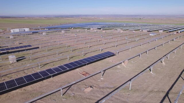 Aerial view of building large solar energy farm under construction. Large-scale solar farm with rows of photovoltaic panels and metal racking under bright sunlight, symbolizing renewable energy, Spain