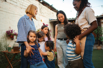 Obraz premium Diverse group of adults and children happily interacting outdoors