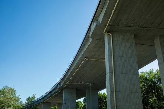 Highway bridge with concrete pillars and curved underside view