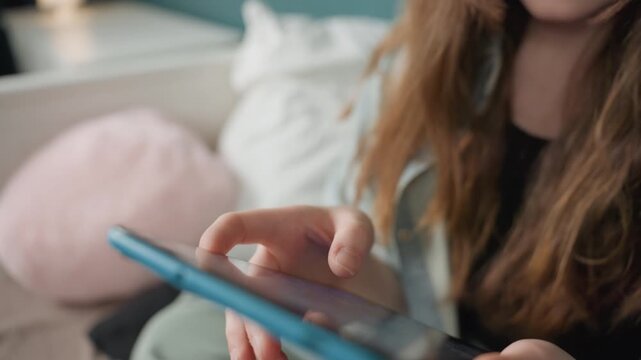 Caucasian girl tapping tablet screen with focused fingers, quick scrolling through messages and app interfaces, notification glow on glass, bedside cushion and soft lamp, social messaging moment