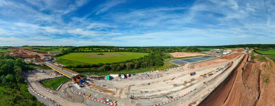 Aerial view of the HS2 High Speed Rail civil engineering works with bridge construction and earthworks across a rural landscape in Southam, England, United Kingdom.