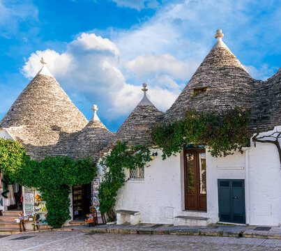 Group of beautiful Trulli, traditional Apulian dry stone hut old houses with a conical roof in Itria Valley, Puglia, Italy
