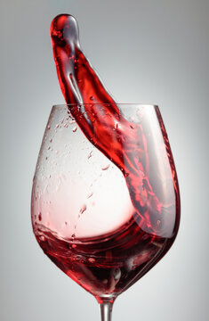 Wine glass with red liquid frozen in movement.