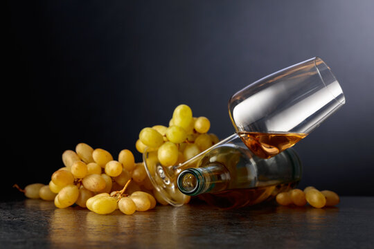 Grapes and white wine on a black background.
