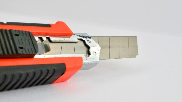 Sharp utility knife on a clear surface, ready for precise cuts for creative projects. Close-up of a stylus on a light background, an essential tool for detailed work.