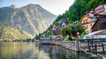 Obraz premium Hallstatt, Austria - September 2nd, 2021: Picturesque view of Hallstatt city with tourists, nestled by the serene lake and surrounded by majestic mountains