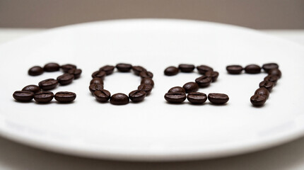 Naklejka premium Coffee beans arranged as 2027 on white plate with shallow focus for breakfast ritual cafe branding roasted aroma seasonal menu morning lifestyle concept cozy banner cafe menu promotion