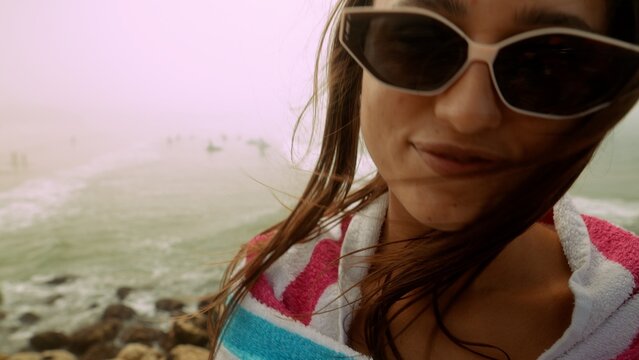 Relaxed female traveler documenting warm sunny day by rocky shoreline