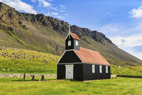Black wooden church in a meadow in front of a cliff, Saurb&aelig;jarkirkja, Saurb&aelig;r, Rau&eth;isandur, Raudisandur, near Patreksfj&ouml;rdur, Westfjords, Iceland