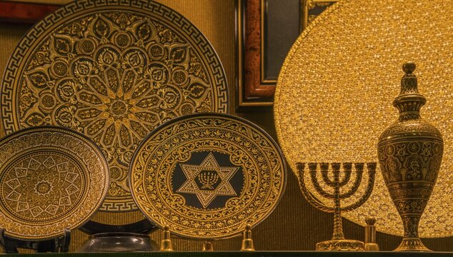 Gold-decorated decorative plates with intricate patterns and symbols, including a menorah and Star of David, presented on stands, Toledo, Castilla-La Mancha, Spain