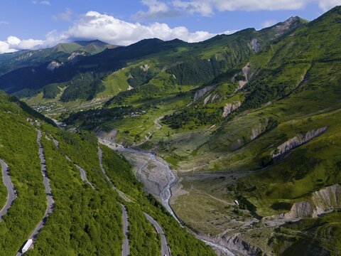 Landscape with green mountains and valley crossed by a river and a road, aerial view, landscape between Kvesheti and Gudauri, White Aragvi River, Mtskheta-Mtianeti region, Georgian Military Road, High Caucasus, Georgia