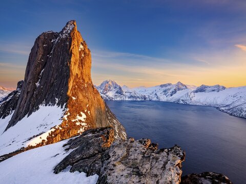 Alpenglow on the steep mountain Segla, fjord Mefjorden with mountains, island Senja, Troms, Norway