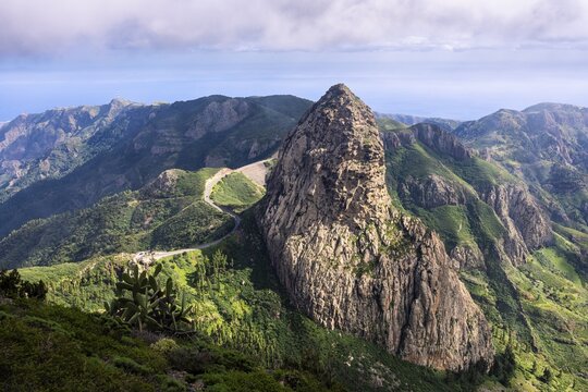 View of the Roque de Agando rock tower, one of La Gomera's landmarks, from the Mirador del Morro de Agando. During the day, sun and clouds, good weather. Monumento Natural de Los Roques, La Gomera, Canary Islands, Spain