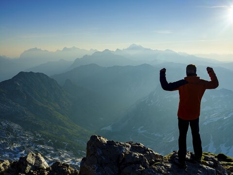 Climbers in victory pose at the summit of Krn 2. 244m, Triglav National Park, Julian Alps, Slovenia