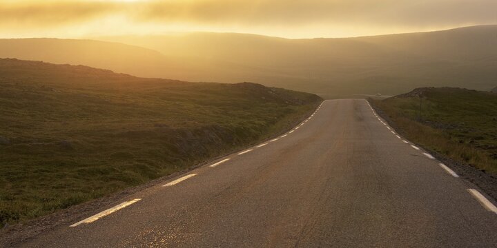 Road through a barren plateau, European route E69, dusk, North Cape, Mager&oslash;ya island, Finnmark County, Norway