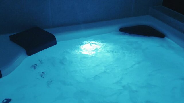 Sparkling water splashes in jacuzzi, pool in golden sunset light, glowing droplets rising 
