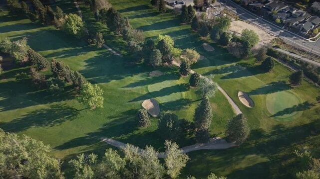 High altitude spring morning drone shot of a fairway at Warm Springs Golf Course, Boise, Idaho. Lush green fairways and scenic spring landscape on a peaceful morning.