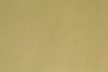 Close-up of a textured pale yellow-green stucco wall, minimalist background, architectural detail, rough surface design. © magic_cinema