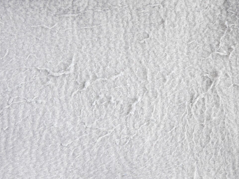 Light gray fleece fabric texture with pilling and lint close up