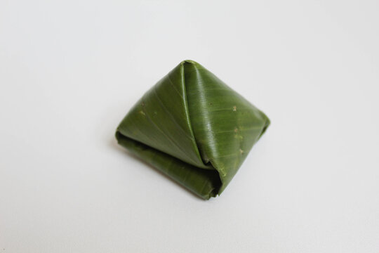 Pyramid like shape of banana leaf, contain traditional snack called Kue Bugis in Indonesia. Isolated in white background