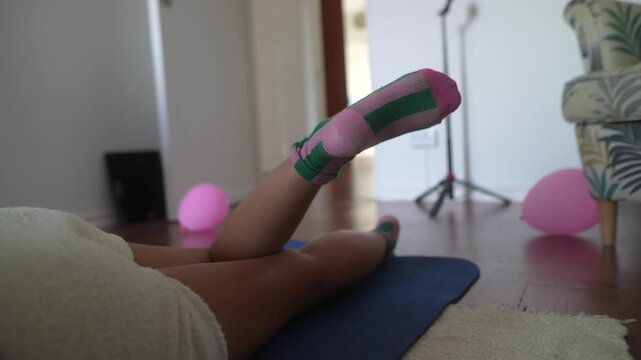 Patient practicing recovery exercises on living room mat
