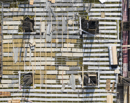 Aerial view of formwork construction with wooden panels, steel rebar columns, and scaffolding at an industrial building site Taiwan.