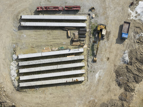 Aerial view of precast concrete elements for bridge construction with an excavator and a truck on a construction site in Taiwan.
