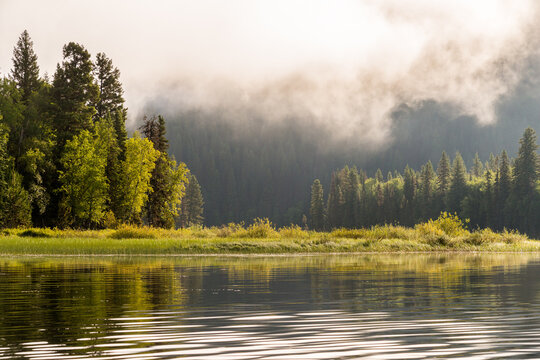 Canada, BC, Bowron Lake Provincial Park.  early morning sun and low clouds over Swan Lake.  Bowron Lakes is a famous canoe circuit in central BC.
