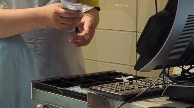 Close up of a cashier hands counting paper money and giving back cash change to a customer at a checkout counter