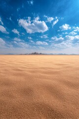 Fototapeta premium Vast desert landscape under a bright blue sky with scattered clouds and gentle sand dunes stretching into the horizon, creating a serene and tranquil atmosphere ideal for nature and outdoor themes,