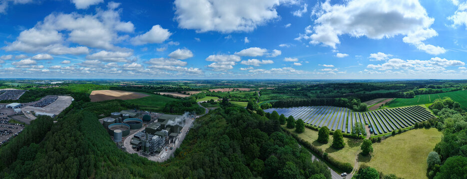 Aerial view of Biogen Atherstone anaerobic digestion plant and a large solar farm surrounded by lush green forests and fields in Atherstone, England, United Kingdom.